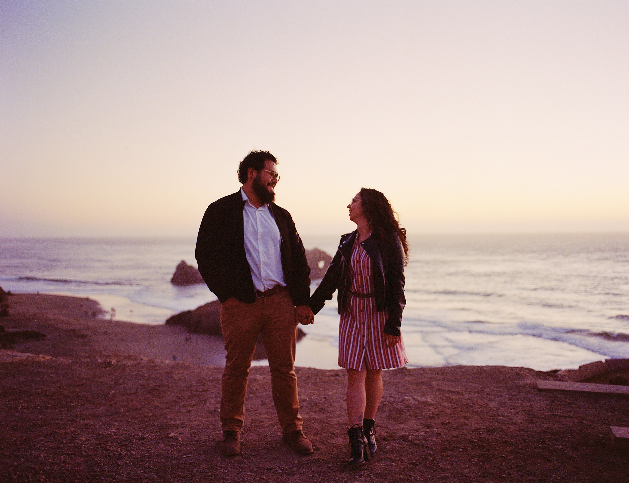 Wedding couple on rocky beach at golden hour